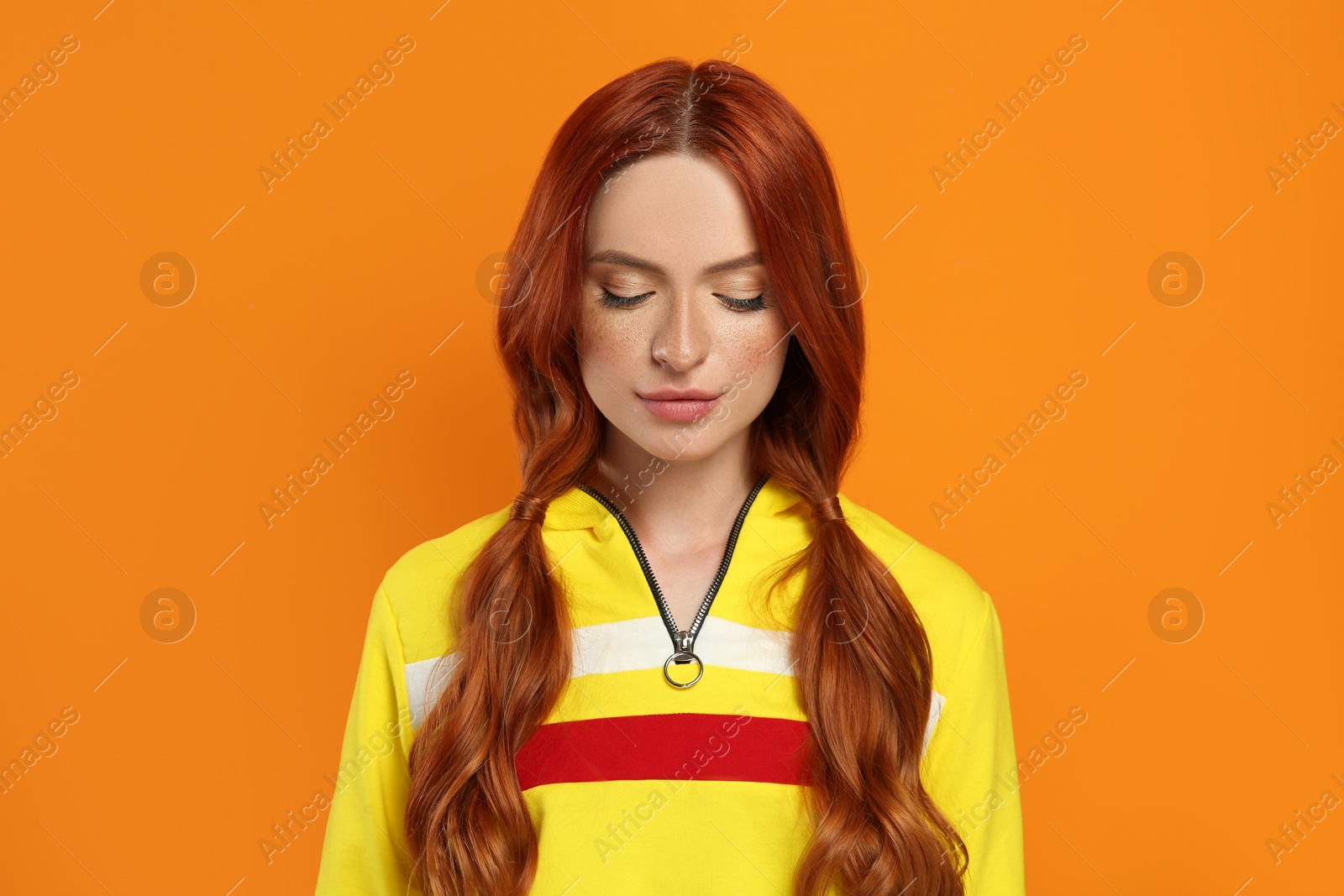 Photo of Beautiful woman with closed eyes on orange background