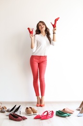 Photo of Young woman with many beautiful shoes indoors