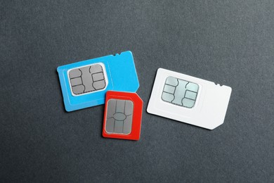 Photo of Different SIM cards on black table, flat lay