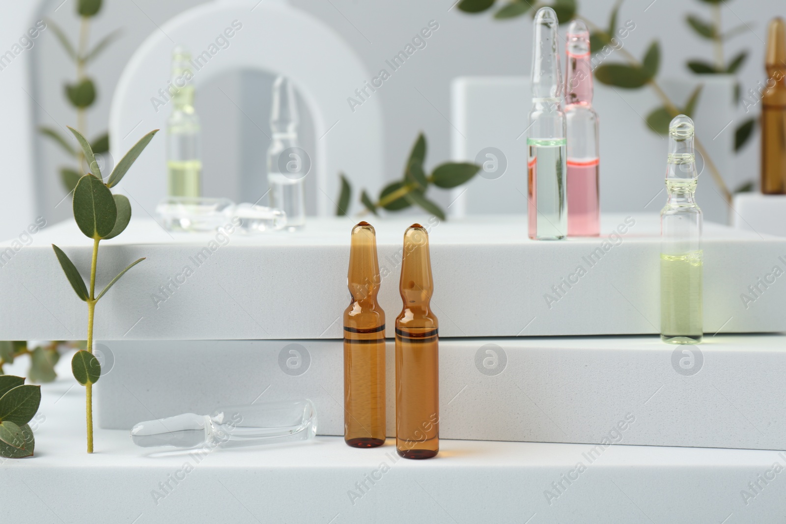 Photo of Stylish presentation of different skincare ampoules on white background, closeup