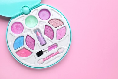 Photo of Decorative cosmetics for kids. Eye shadow palette with lipstick on pink background, top view. Space for text