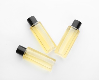 Photo of Mini bottles with cosmetic products on white background, top view. Hotel amenities