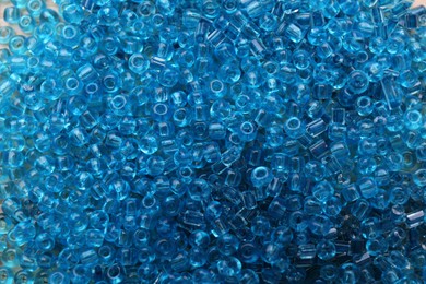 Photo of Bright light blue glass beads as background, top view