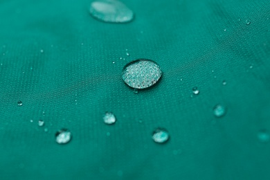 Photo of Green waterproof fabric with water drops as background, closeup