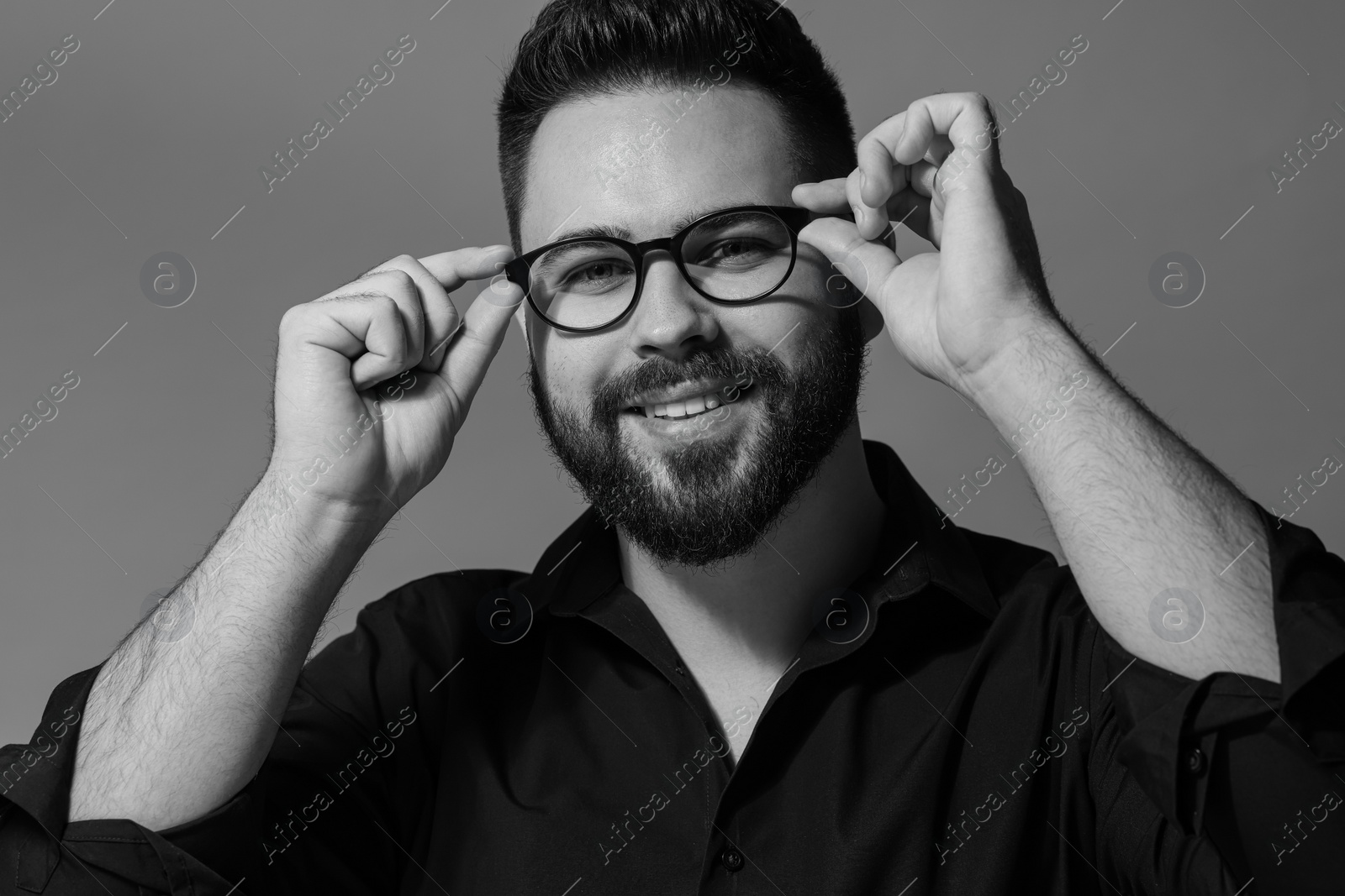 Photo of Portrait of handsome bearded man on grey background. Black and white effect