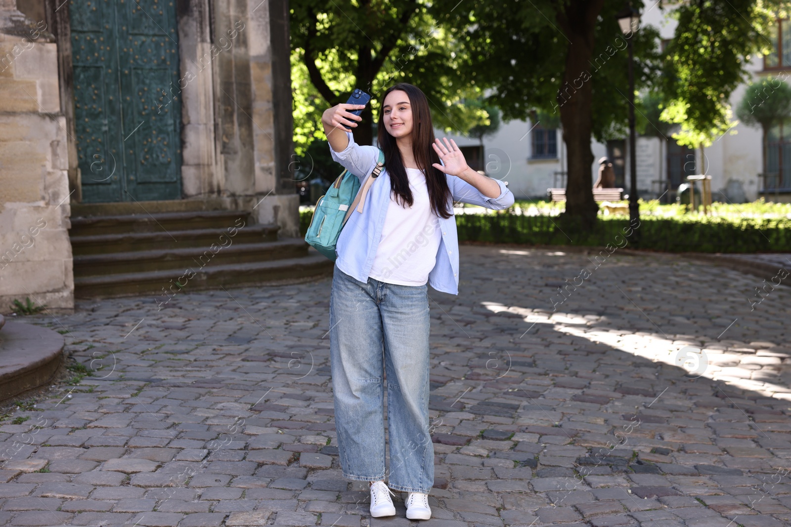 Photo of Beautiful travel blogger with smartphone streaming outdoors