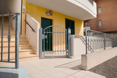 Photo of Stylish building entrance with intercom on metal gate