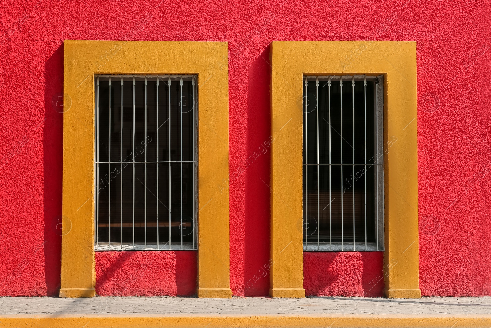 Photo of Exterior of red building with windows and steel grilles