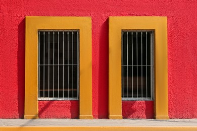 Exterior of red building with windows and steel grilles