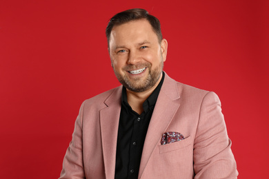 Portrait of happy mature man on red background