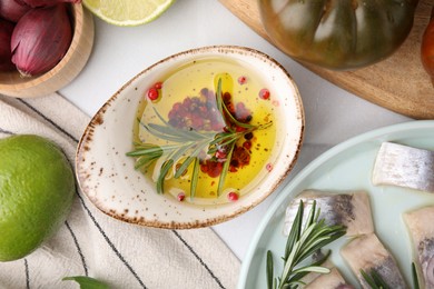 Photo of Tasty fish marinade with rosemary and products on light table, flat lay