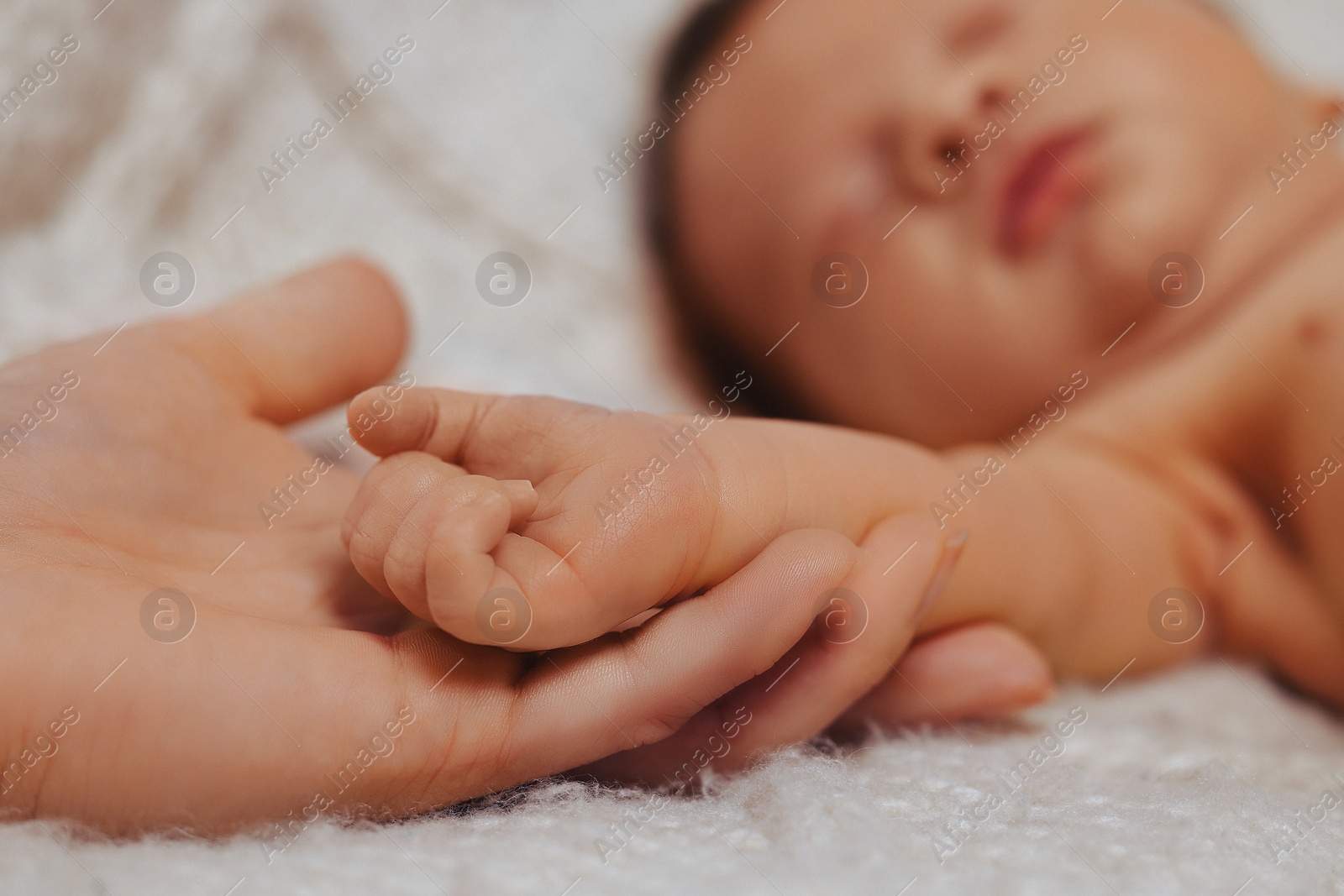 Photo of Mother with her newborn baby on beige blanket, closeup. Lovely family