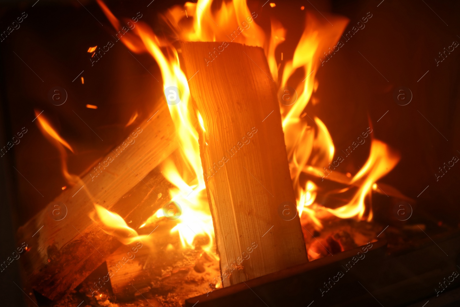 Photo of Fireplace with burning wood, closeup view. Winter vacation