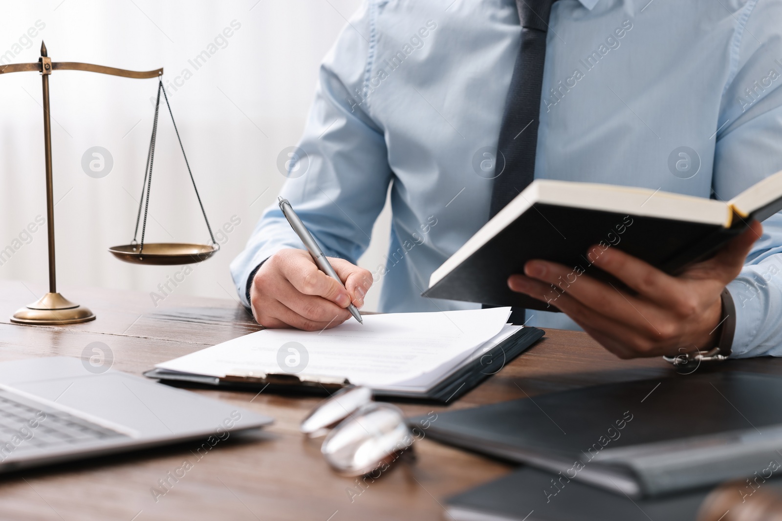 Photo of Lawyer working at wooden table in office, closeup