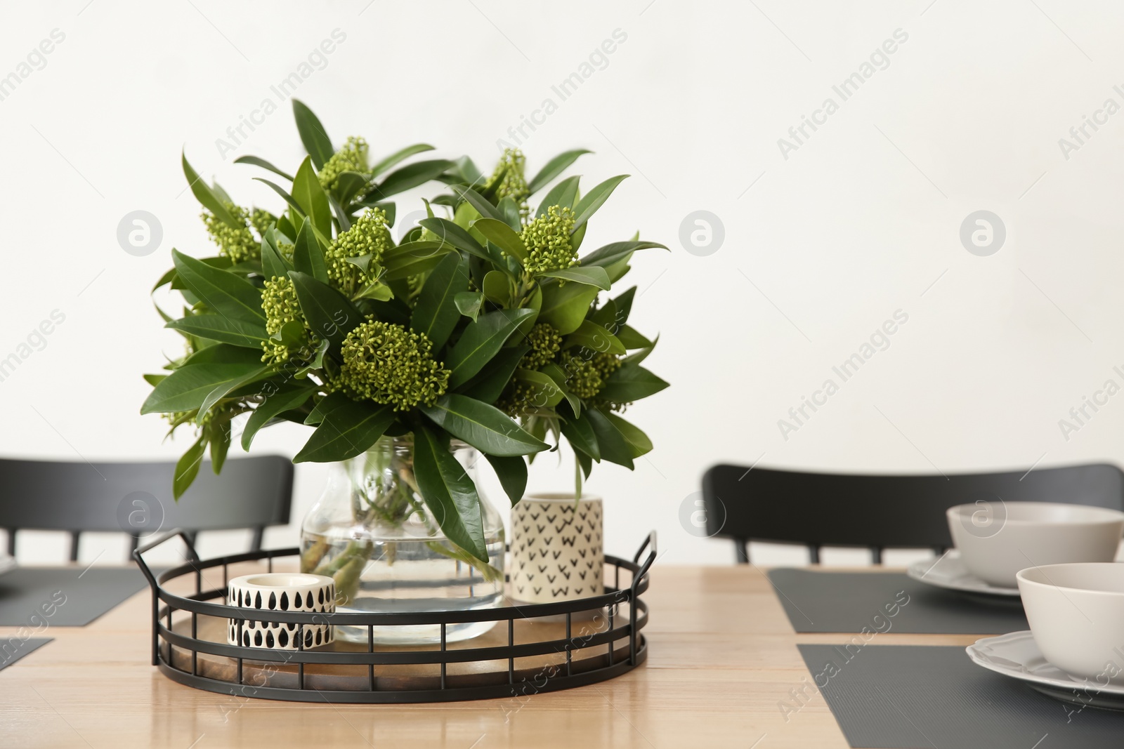 Photo of Fresh bouquet on dining table in room, closeup. Interior design