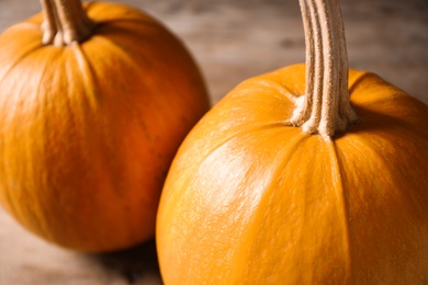 Photo of Ripe pumpkins on wooden background, closeup. Holiday decoration