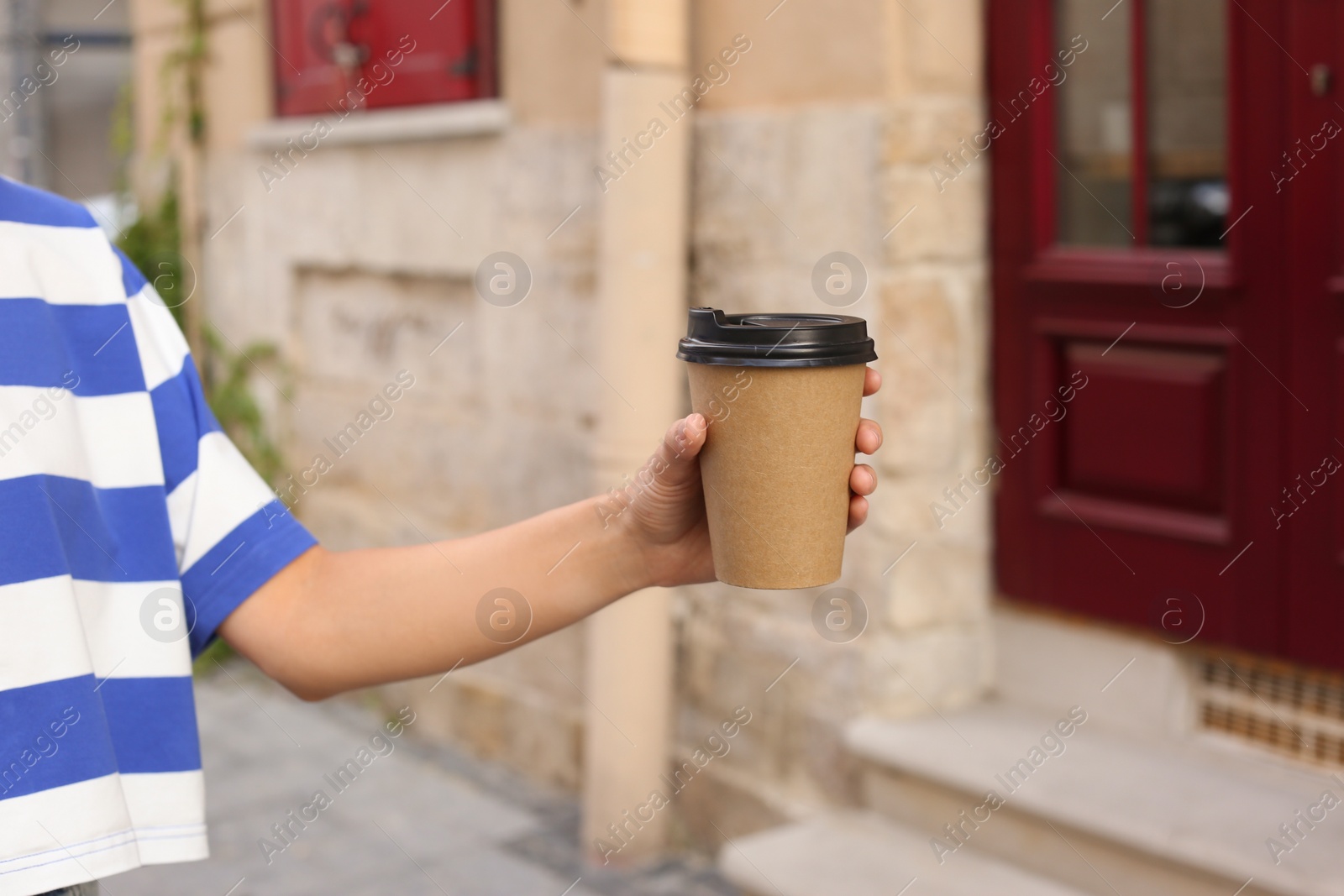 Photo of Coffee to go. Woman with paper cup of drink outdoors, closeup