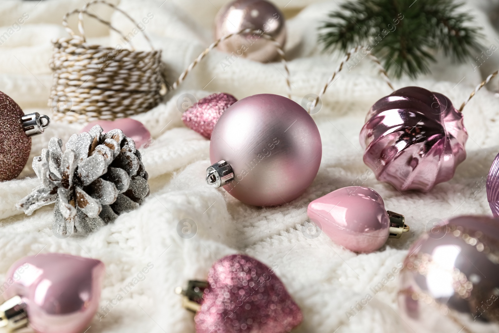 Photo of Beautiful pink Christmas baubles on white knitted plaid
