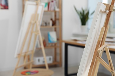 Wooden easel with canvas in artist's studio, space for text. Creative hobby