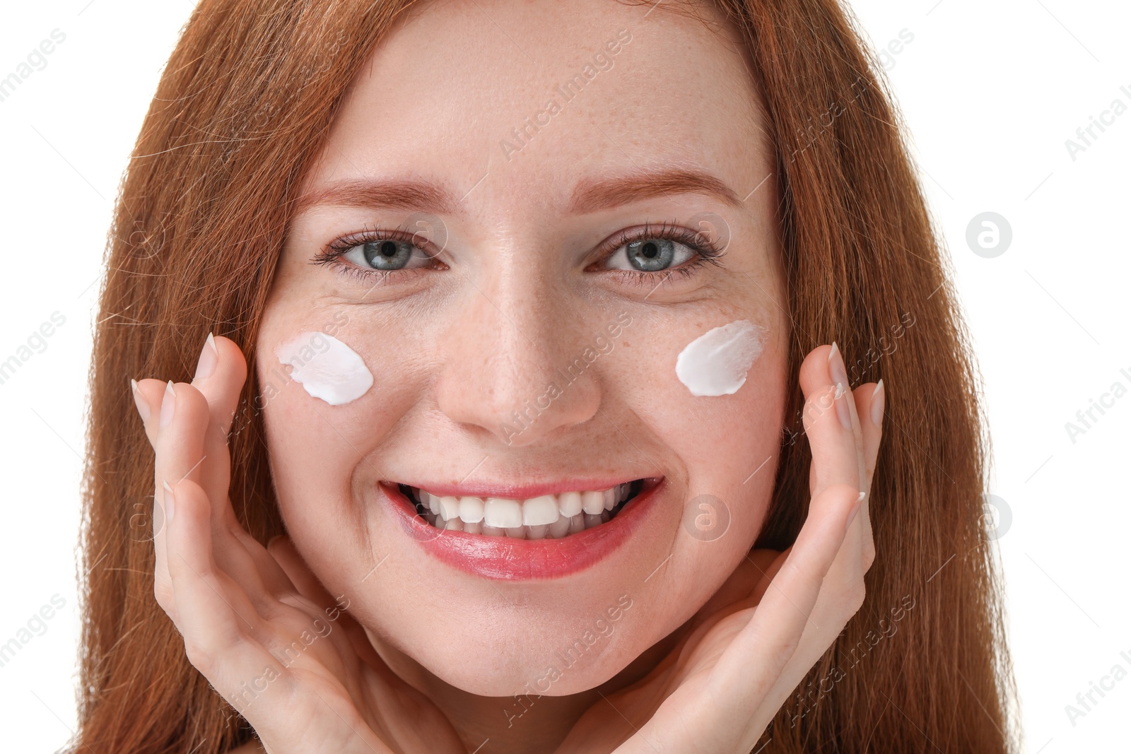 Photo of Smiling woman with freckles and cream on her face against white background, closeup