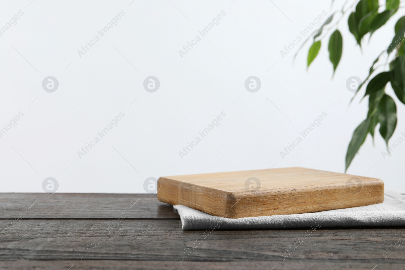 Photo of Empty board and towel on wooden table. Space for text