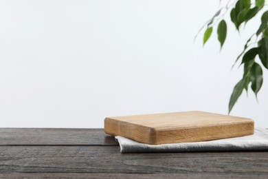 Photo of Empty board and towel on wooden table. Space for text