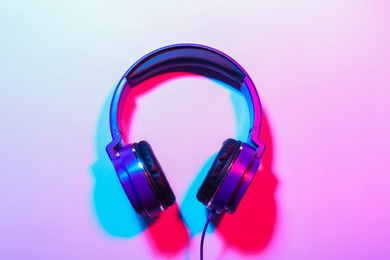 Photo of Stylish headphones on color background, top view