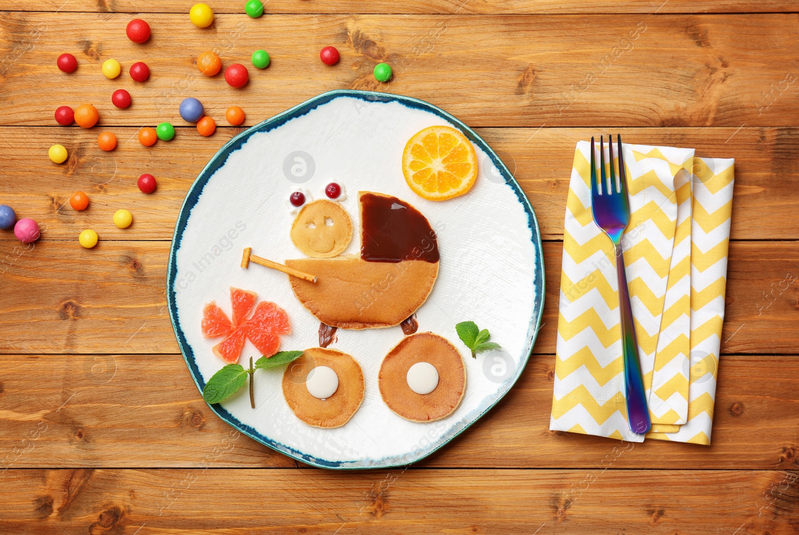 Photo of Funny pancakes for kids breakfast on wooden table, top view