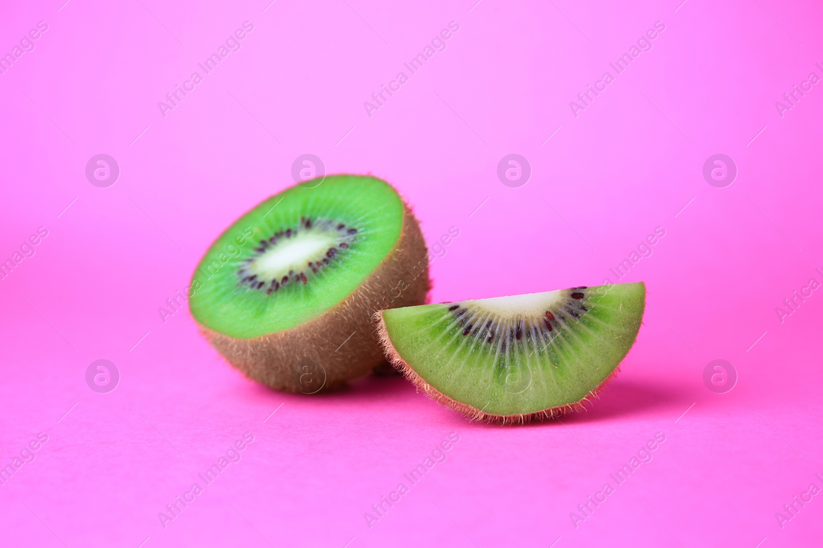 Photo of Cut fresh ripe kiwi on pink background
