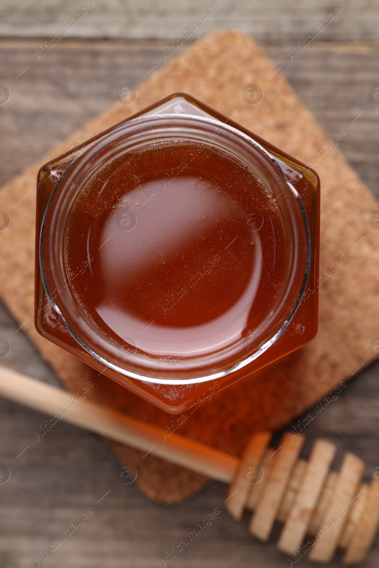 Photo of Sweet honey in jar and dipper on table, flat lay