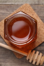 Sweet honey in jar and dipper on table, flat lay