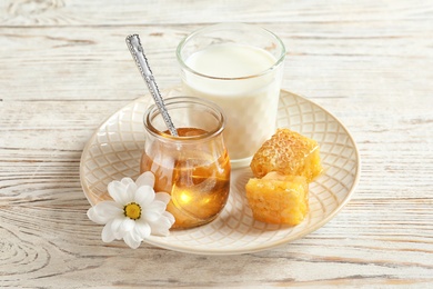 Photo of Beautiful composition with milk and honey on wooden background