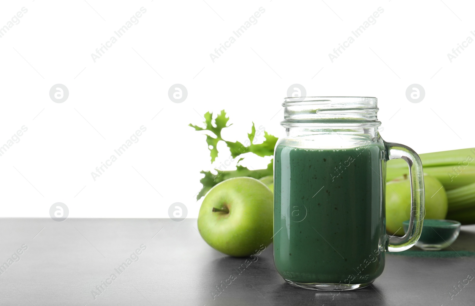 Photo of Composition with mason jar of spirulina smoothie on table against white background. Space for text