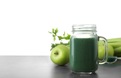 Photo of Composition with mason jar of spirulina smoothie on table against white background. Space for text
