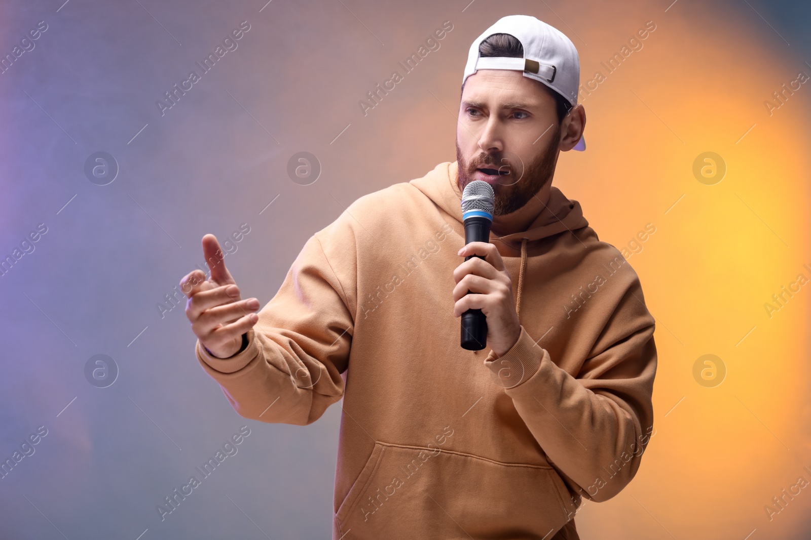 Photo of Singer with microphone rapping in color lights