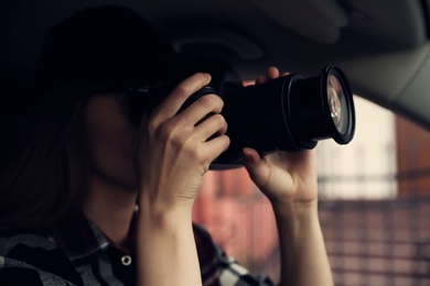 Photo of Private detective with camera spying from car, focus on lens