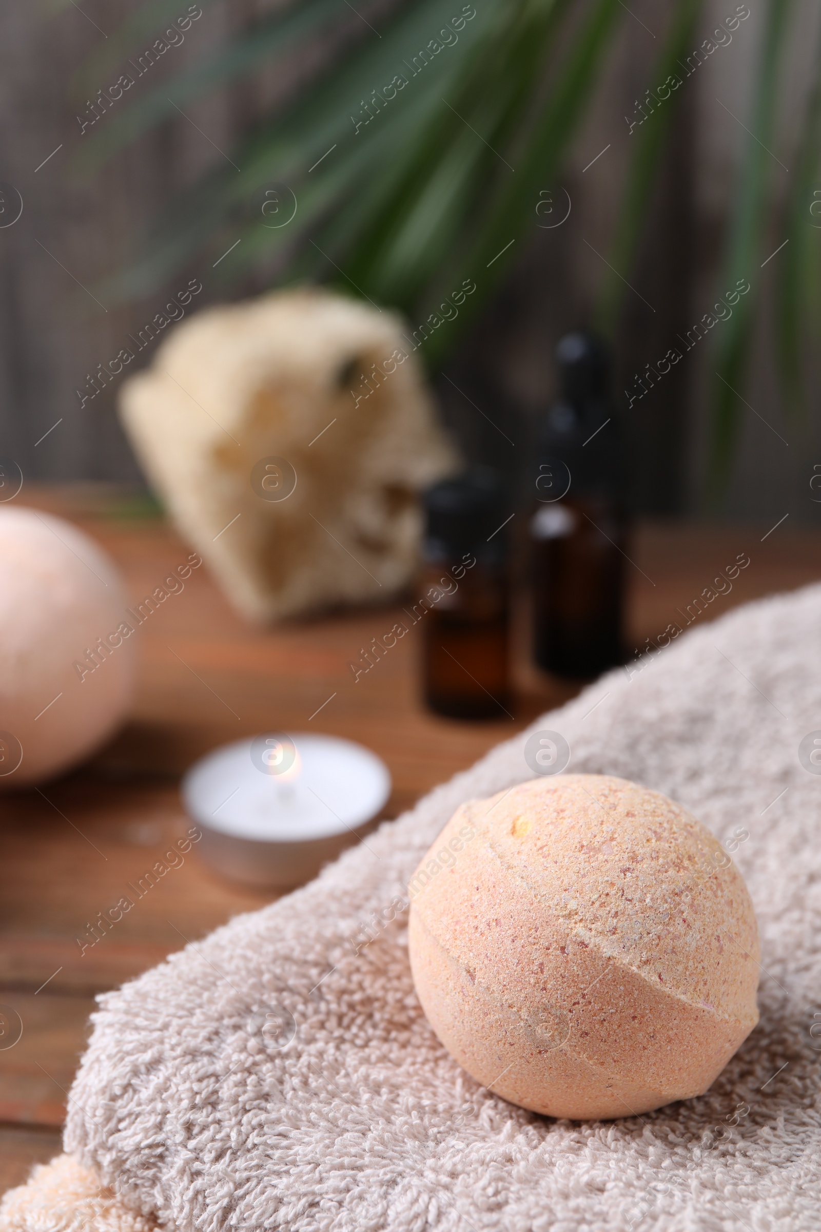 Photo of Beautiful aromatic bath bomb on towel, closeup. Space for text