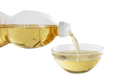 Pouring cooking oil from bottle into bowl on white background, closeup