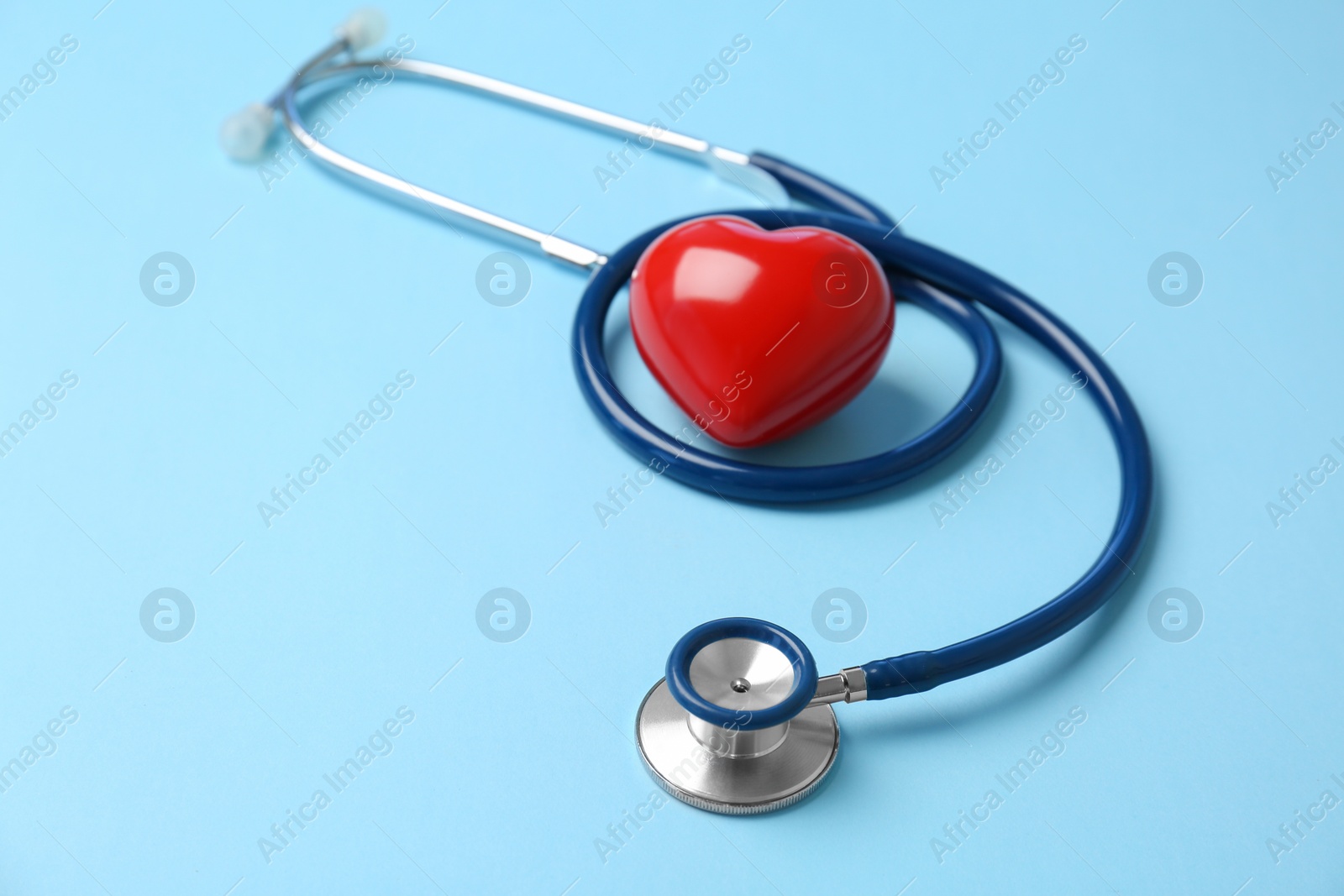 Photo of Stethoscope and heart model on color background. Medical equipment