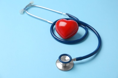 Stethoscope and heart model on color background. Medical equipment