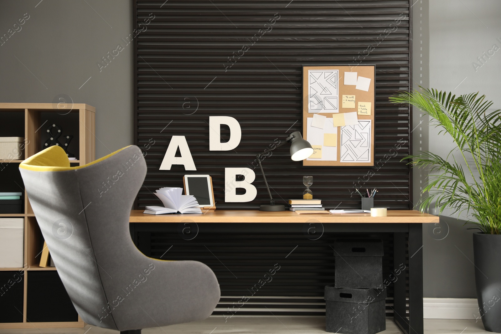 Photo of Comfortable workplace with wooden table and armchair