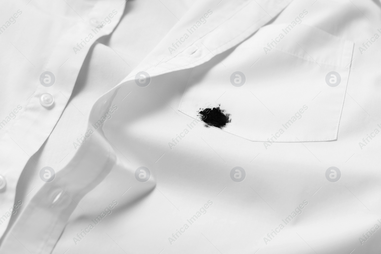 Photo of Stain of black ink on white shirt, closeup