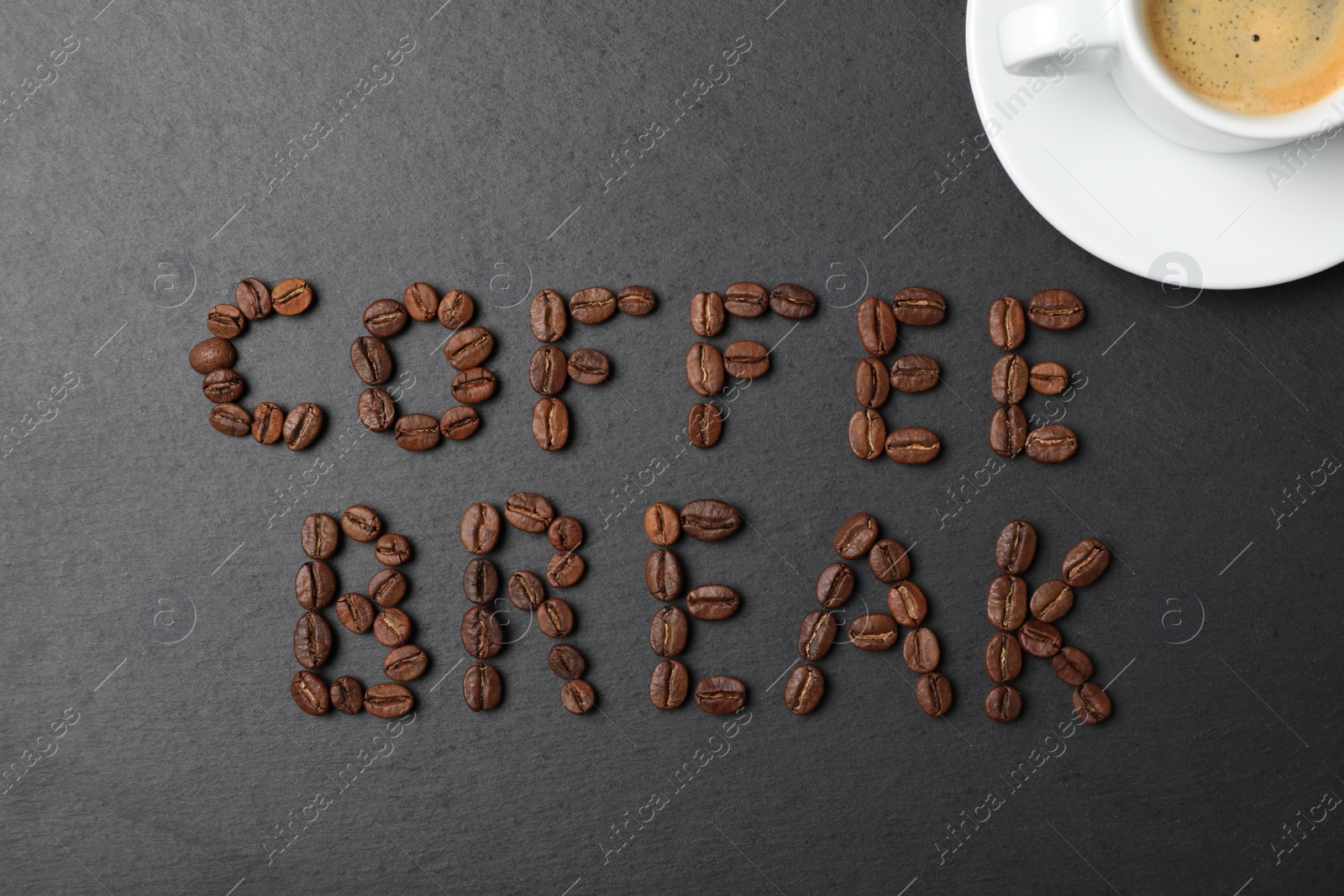 Photo of Phrase Coffee Break made with beans and cup of drink on black background, flat lay
