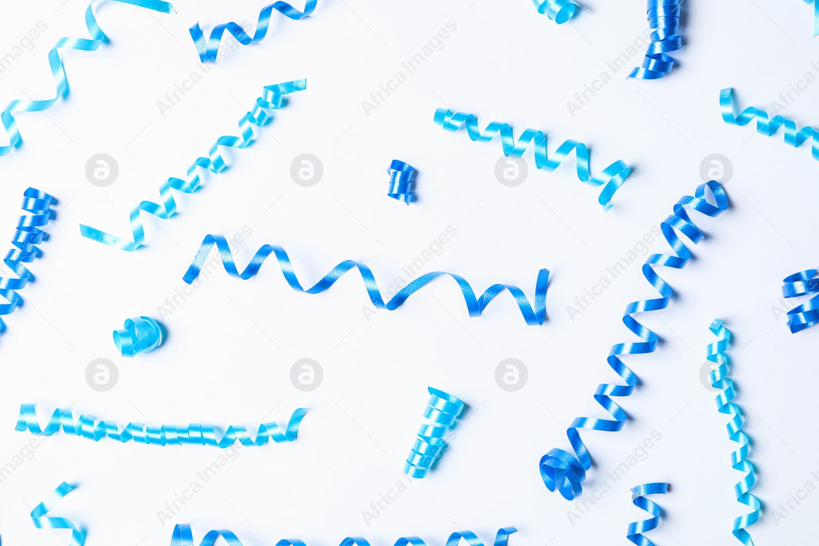 Photo of Blue serpentine streamers on white background, top view