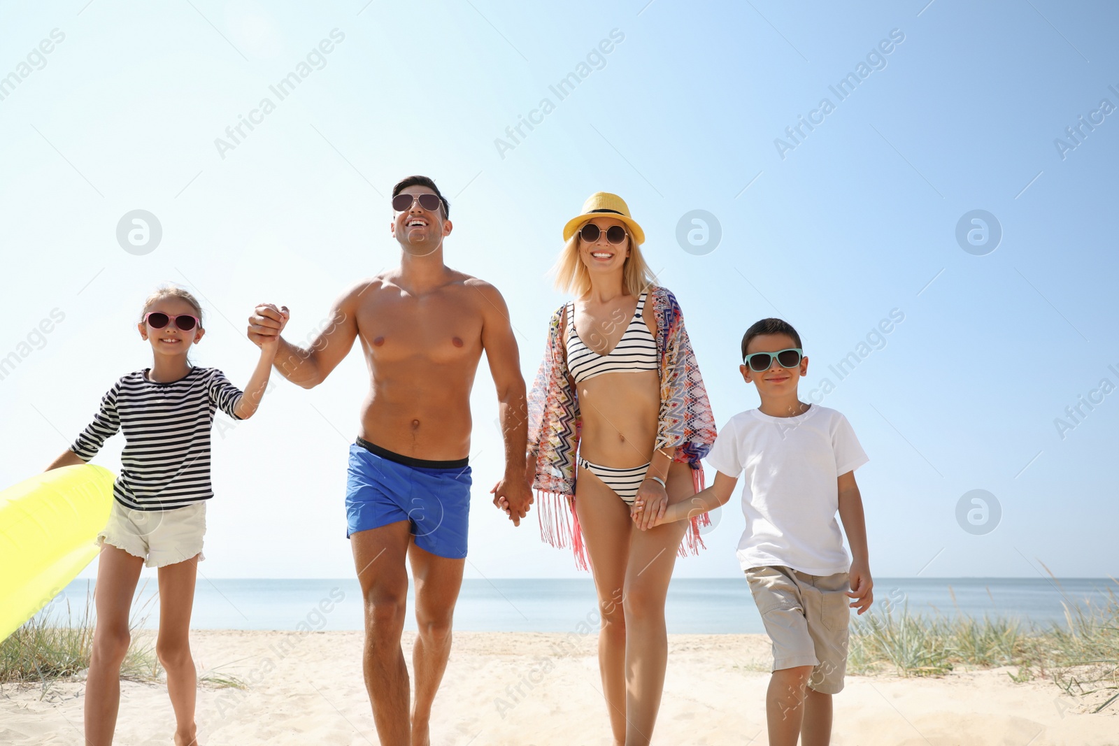 Photo of Family with inflatable ring at beach on sunny day