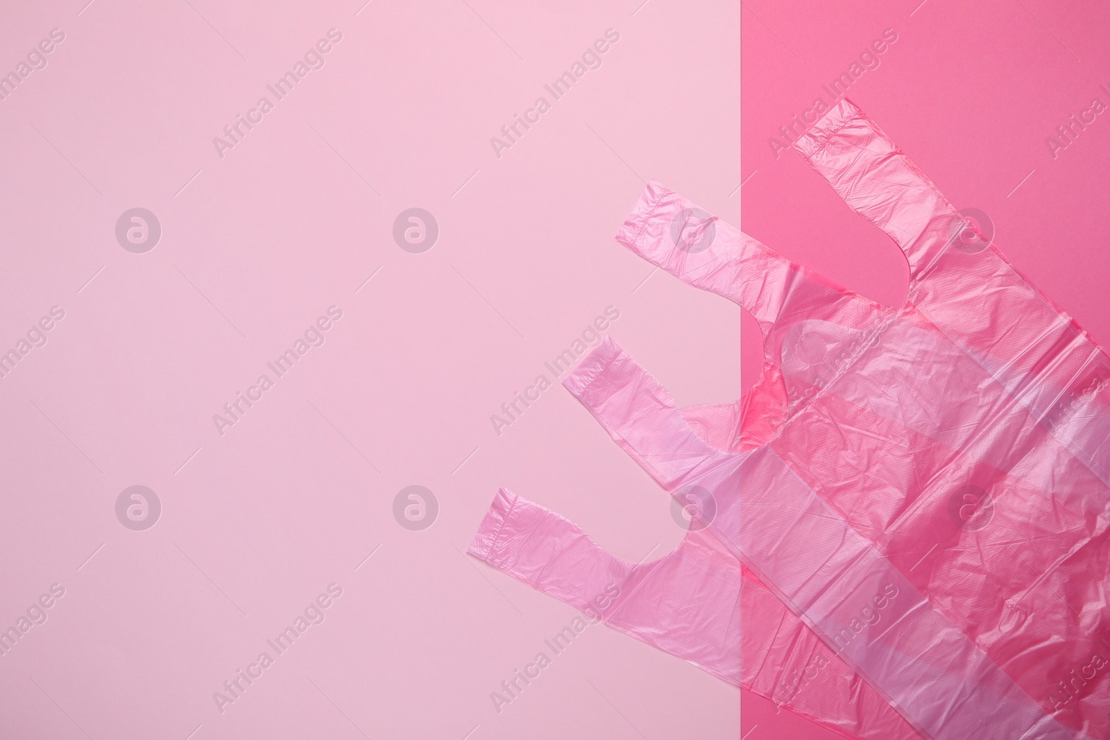 Photo of Plastic bags on pink background, top view. Space for text