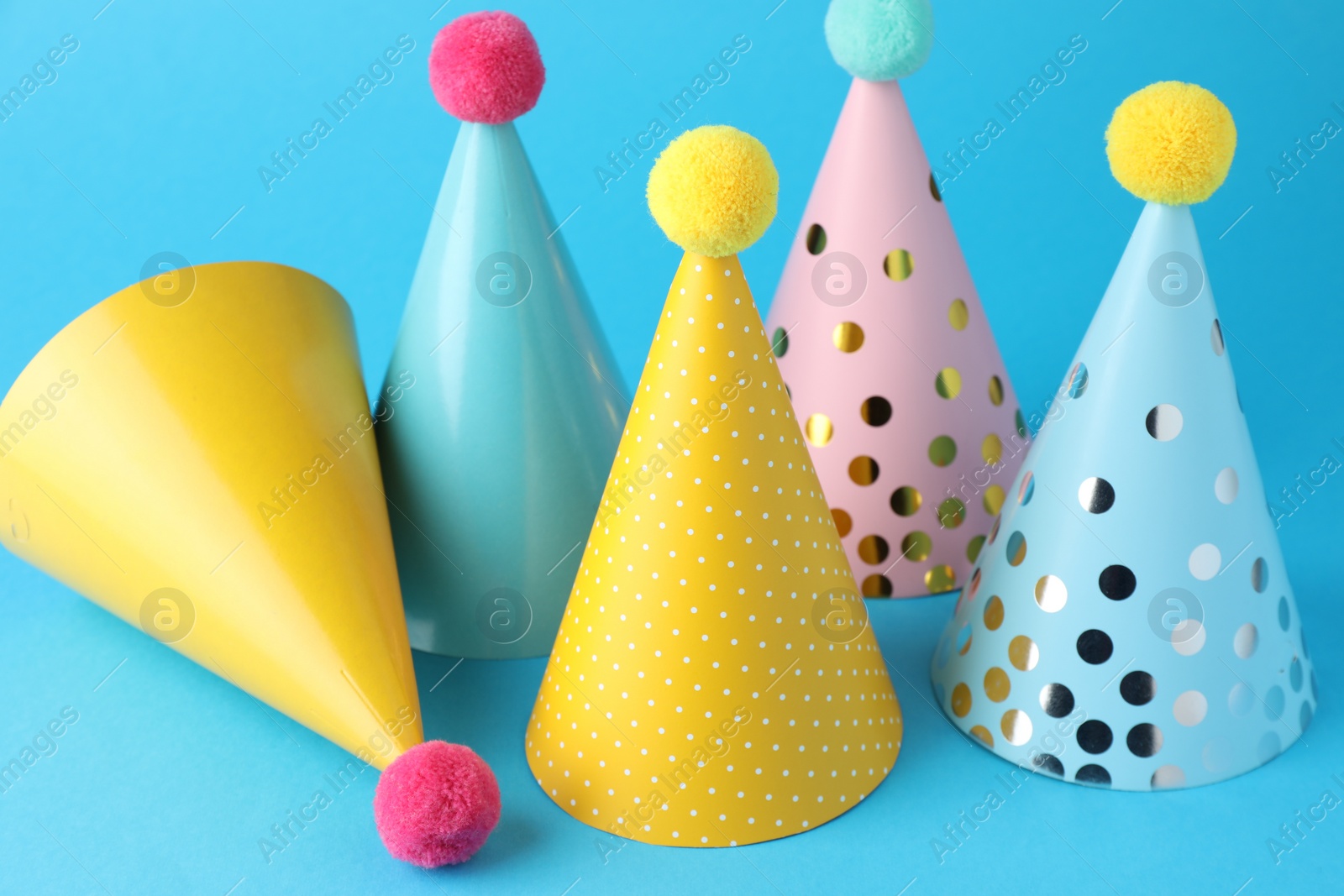 Photo of Colorful party hats on light blue background