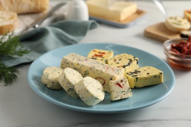 Photo of Different types of tasty butter and chili pepper on white marble table, closeup