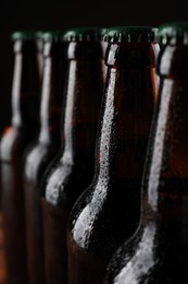 Many bottles of beer on dark background, closeup