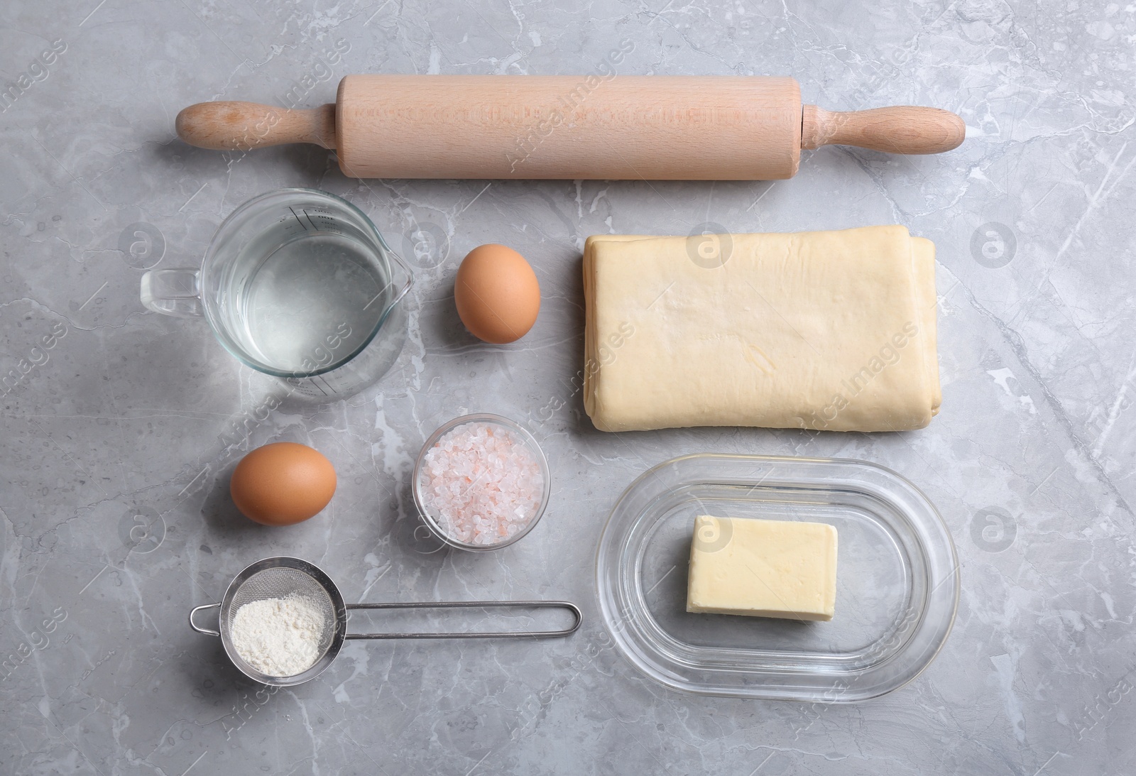 Photo of Flat lay composition with puff pastry dough and ingredients on grey table